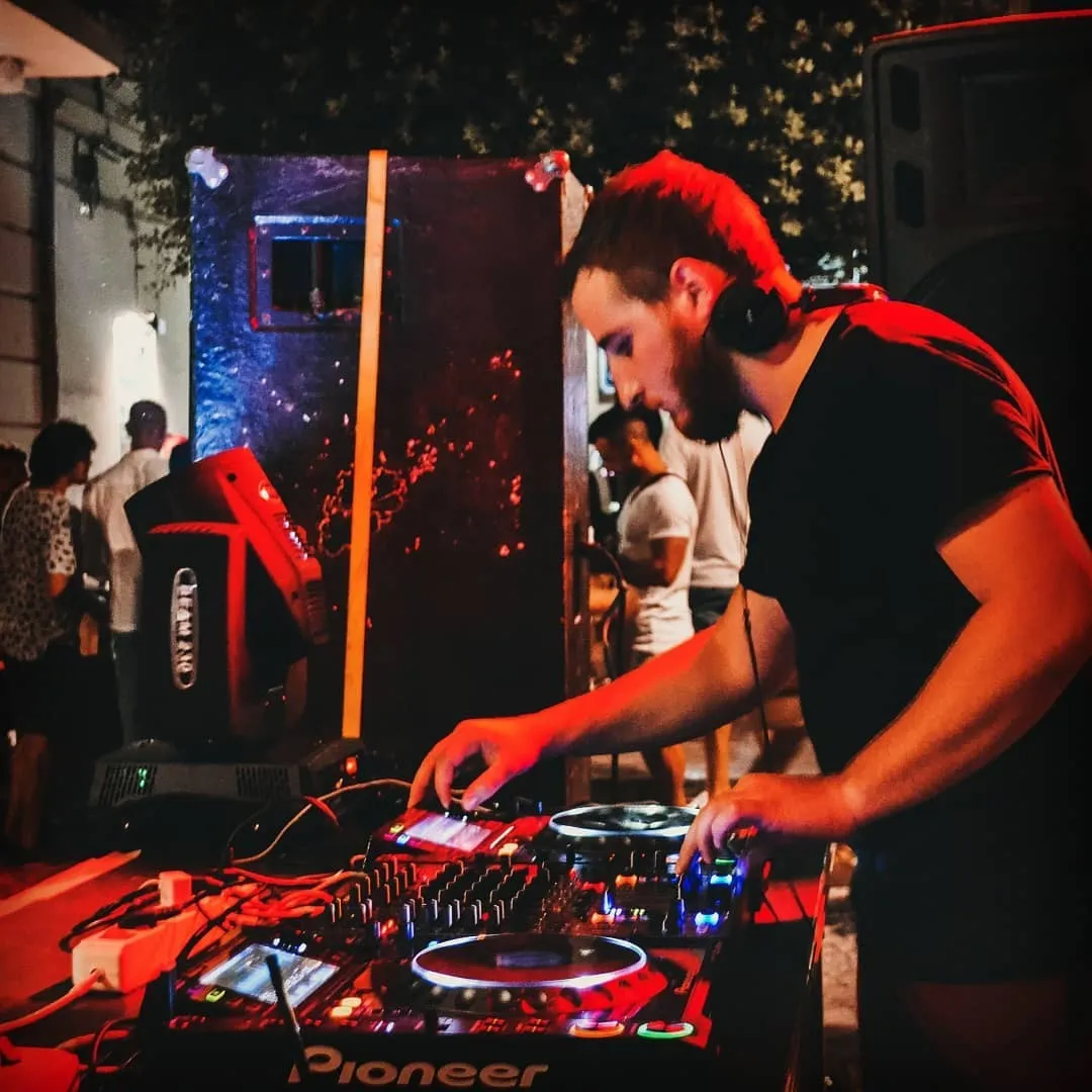 Redfire performing behind the decks at an outdoor event
